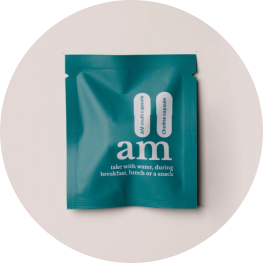 A teal blue am brand multi-capsule sachet with white text, displayed on a light beige circular background.