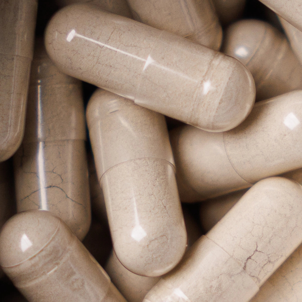 A close-up pile of iron capsules with a smooth, slightly glossy surface.